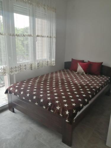 a large bed in a room with a window at Apartman Jela in Soko Banja