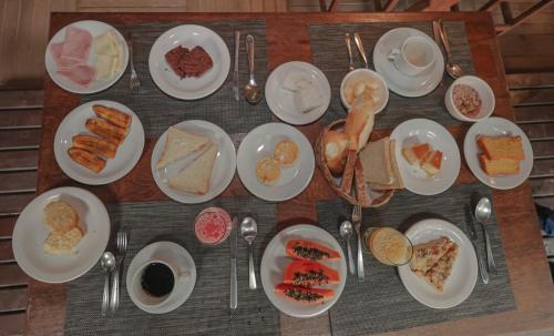 une table pleine d'assiettes de nourriture sur une table dans l'établissement Pousada Saudosa Maloca, à Arraial d'Ajuda