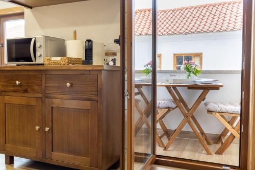 a kitchen with a counter and a table with a microwave at Casa da Fonte in Vilarelhos