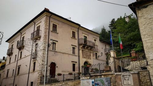 a large building with balconies and a flag on it at Il Rifugio del Brigante in Sante Marie