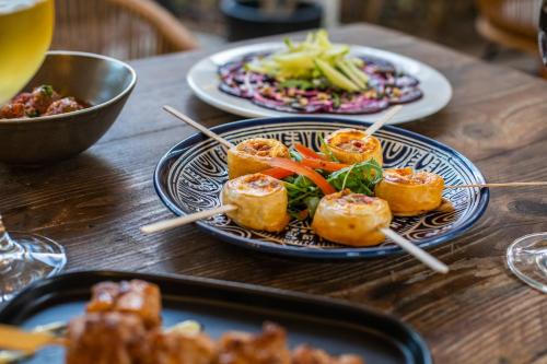 a wooden table with plates of food on chopsticks at Boutique Hotel 't Klooster in Willemstad