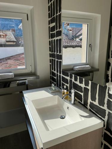 a bathroom with a white sink and two windows at Venzhome in Venzone