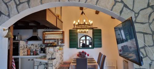 a dining room with a table and a stone wall at Apartments Misini Dvori in Stomorska