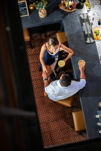 a woman standing next to a man under a table at Boutique Hotel 't Klooster in Willemstad