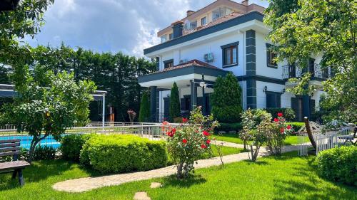 a large house with a garden in front of it at Heaven White Palace in Bostancı