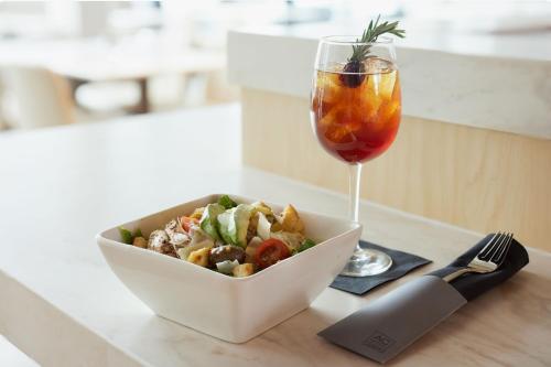 a bowl of salad and a drink on a table at AC Hotel Frisco Colorado in Frisco