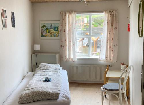 a bedroom with a bed and a desk and a window at Guesthouse at the boat harbour in Tórshavn