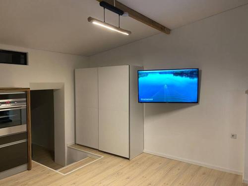 a kitchen with a flat screen tv on the wall at Moderne EG 2-Zimmer Wohnung in Trier
