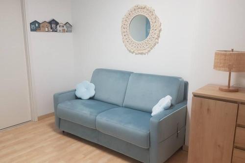 a blue couch in a living room with a mirror at La MAISON BLEUE, Smeg Bleu azur in Évian-les-Bains