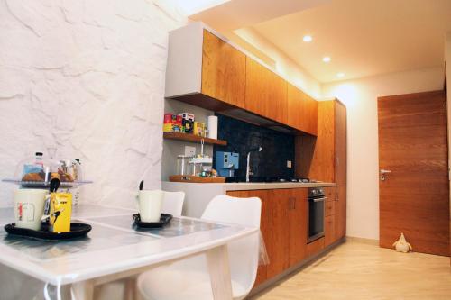 uma cozinha com uma mesa branca e cadeiras brancas em Albatros Suite Home em Pozzuoli