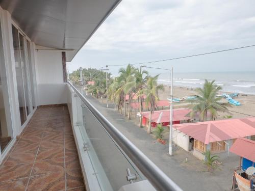 a balcony with a view of the beach and buildings at Margaritas Palace Hotel in Canoa