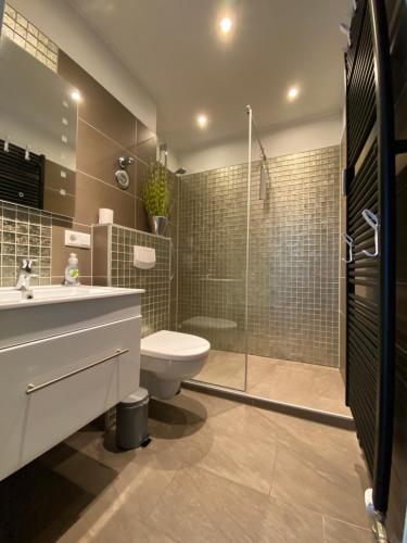 e bagno con servizi igienici, lavandino e doccia. di Luxus Wohnung & Apartment nähe Hannover & Messe ad Hannover