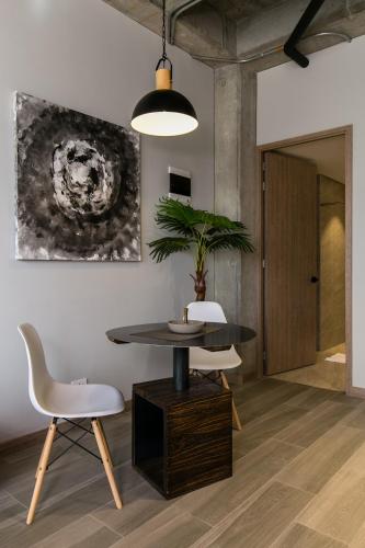 a dining room with a table and chairs and a potted plant at Factory Lofts Hotel in Medellín