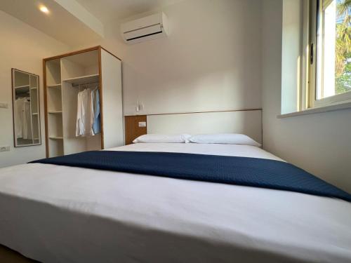 a large white bed in a bedroom with a window at SUNSEA - Enjoy Your Family in Capo Vaticano