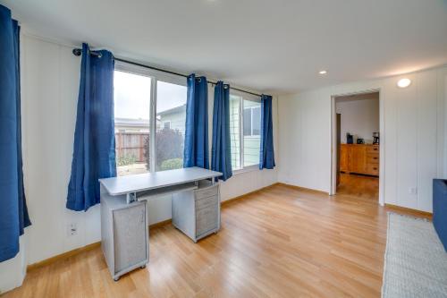 an empty room with a desk and blue curtains at Seaside Vacation Rental with Patio Near Monterey Bay in Seaside
