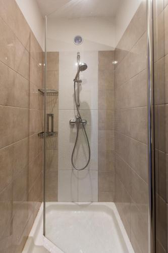 a shower with a glass door in a bathroom at Olive Hill Apartment in Portorož