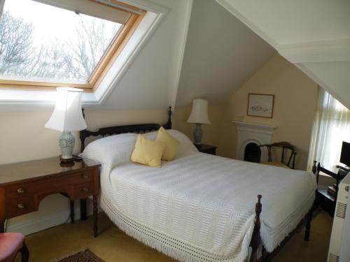 a bedroom with a white bed and a window at Broadlands Gate in Brockenhurst