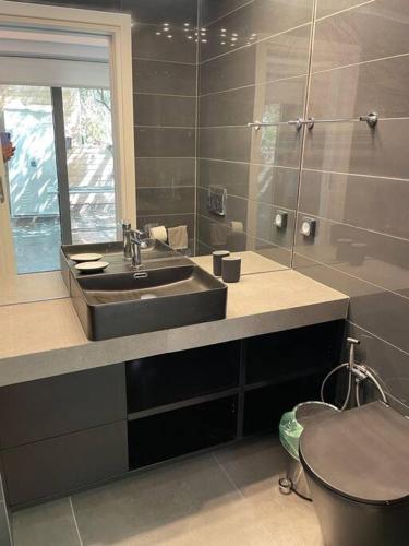 La salle de bains est pourvue d'un lavabo et de toilettes. dans l'établissement Charming Coastal Retreat, à Anavyssos