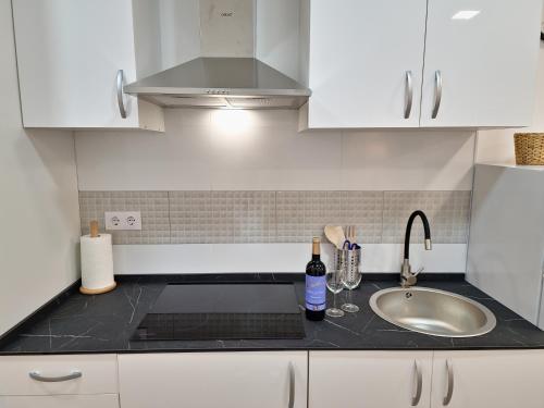 a kitchen with white cabinets and a sink and a sink at Apartamentos Bielsa 'Madrid Río' in Madrid