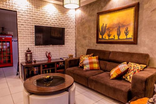 a living room with a couch and a table at Casa Duplex Aconchegante in Campina Grande