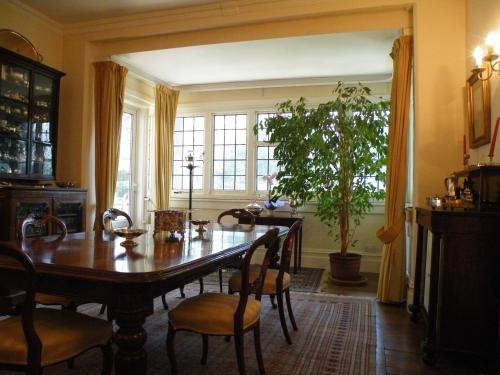 a dining room with a table and a potted plant at Broadlands Gate in Brockenhurst
