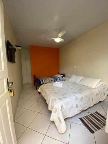 a bedroom with a large bed and a tv at Pousada Arcanjo Rafael in Urubici