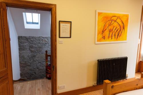a hallway with a door to a room with a radiator at Schoolhouse in Ballater