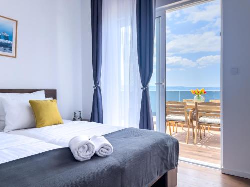 1 dormitorio con 1 cama con toallas en Apartments Goro en Podstrana