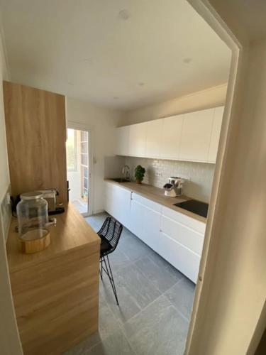 une cuisine avec des armoires blanches et un comptoir dans l'établissement Appartement Cosy Avec Terrasse Parking Proche Plages et Calanques, à Marseille