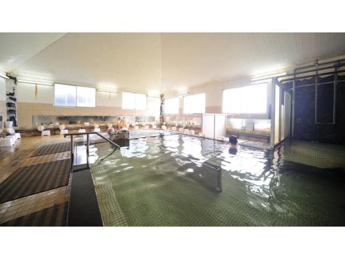 Tennen Onsen Kakenagashi no Yado Hotel Pony Onsen - Vacation STAY 50916v في تووادا: مسبح كبير في مبنى كبير