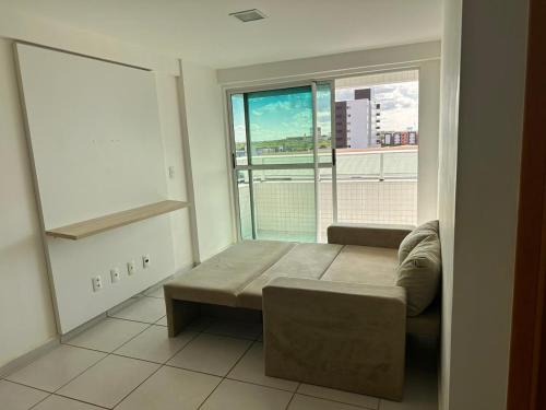a living room with a couch and a large window at Apartamento West Flat in Mossoró