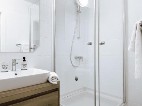 a white bathroom with a shower and a sink at Apartments Goro in Podstrana