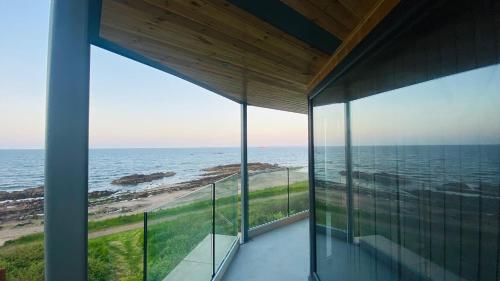 a view of the ocean from the balcony of a house at Luxury beach front rooms- PMA in Kirkcaldy