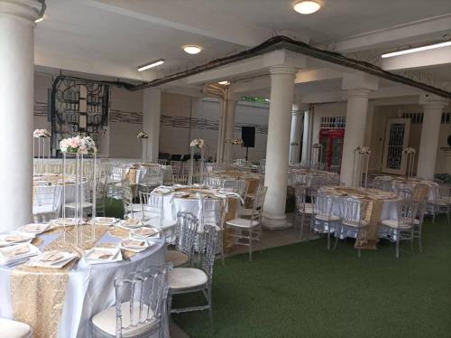 un salón de banquetes con mesas y sillas blancas en HAPPY RESIDENCES Japoma Stadium, en Douala