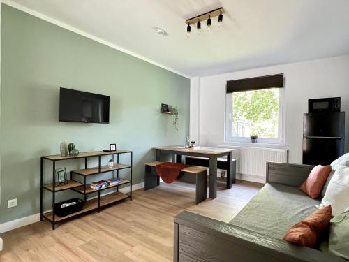 ein Wohnzimmer mit einem Sofa und einem Tisch in der Unterkunft Sali - R1 - Apartmenthaus, WLAN, TV in Remscheid
