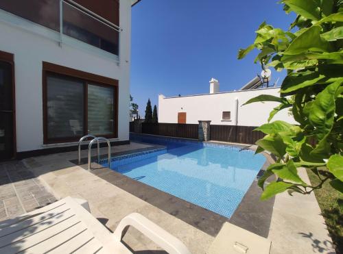 a swimming pool in front of a house at Denizolgun Homes Eska Villa 1+1 in Dalaman