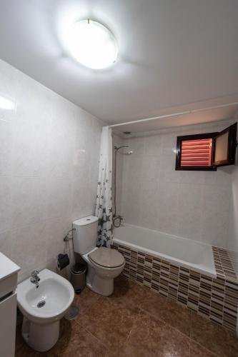a bathroom with a toilet and a tub and a sink at SUN BAY in Caleta De Fuste