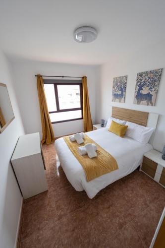 a bedroom with a large bed and a window at SUN BAY in Caleta De Fuste