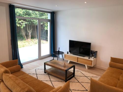 un salon avec un canapé et une télévision dans l'établissement Modern House next Disneyland, à Esbly