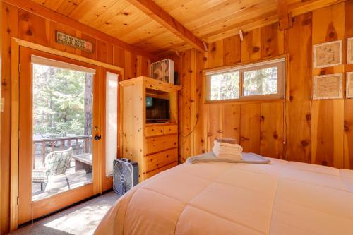Blockhausschlafzimmer mit einem Bett und einem Balkon in der Unterkunft Cozy Cabin about 3 Mi to Big Trees State Park! in Arnold