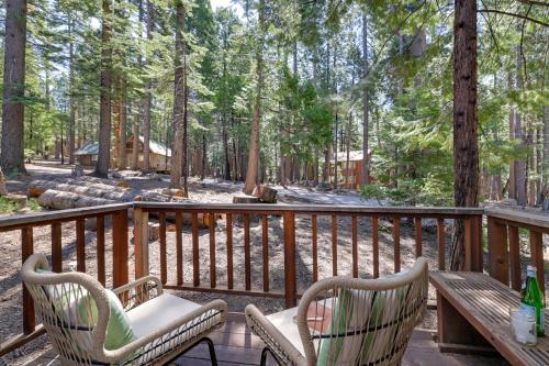 two chairs and a table on a deck with a forest at 3 Mi to Big Trees State Park Cabin with Scenic Deck in Arnold