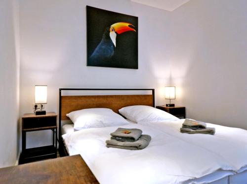 1 dormitorio con 2 camas y una pintura de un pingüino en HappySide TinyHouse - Terasse - Hunde bis 5 KG, en Leipzig