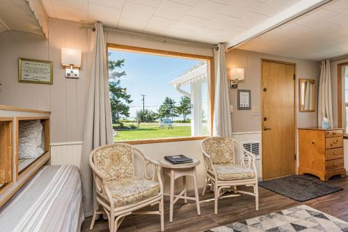 une chambre avec deux chaises, une table et une fenêtre dans l'établissement Juan de Fuca Cottages, à Sequim