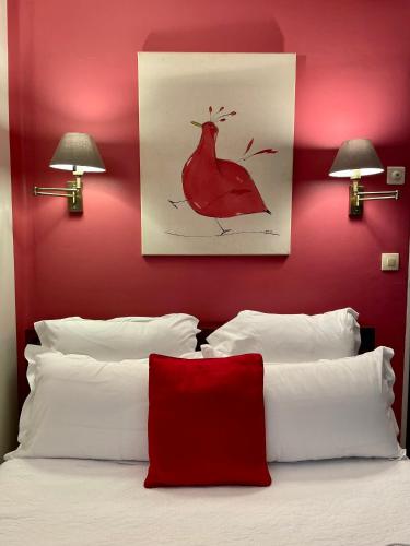 a bedroom with a red wall with two lamps and a bed at Hotel l'Impératrice in Fort-de-France