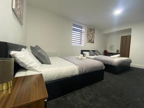 a hotel room with two beds and a table and a desk at Hotel Royal in Blackburn