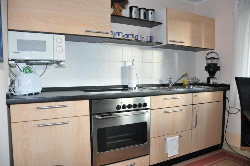 uma cozinha com um fogão e um micro-ondas em Ferienwohnung Tensfeldt em Lübben