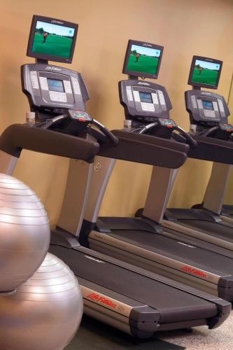 a row of treadmill machines with screens on them at Hampton Inn & Suites Downers Grove Chicago in Downers Grove