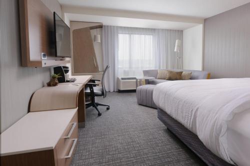 a hotel room with a bed and a desk at Courtyard by Marriott Austin Pflugerville in Pflugerville