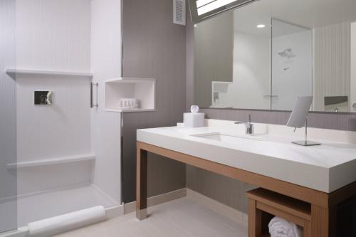 a bathroom with a white sink and a shower at Courtyard by Marriott Austin Pflugerville in Pflugerville