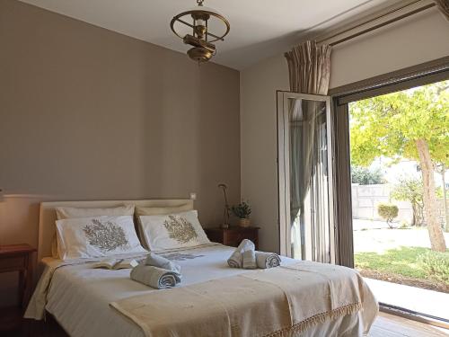 sypialnia z dużym łóżkiem i dużym oknem w obiekcie Seaside retreat house w mieście Paralía Sergoúlas